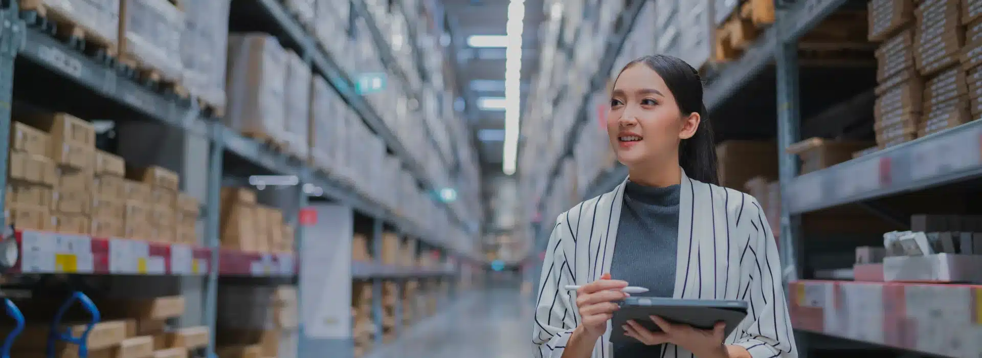 Professional woman with tablet conducting inventory in modern warehouse facility
