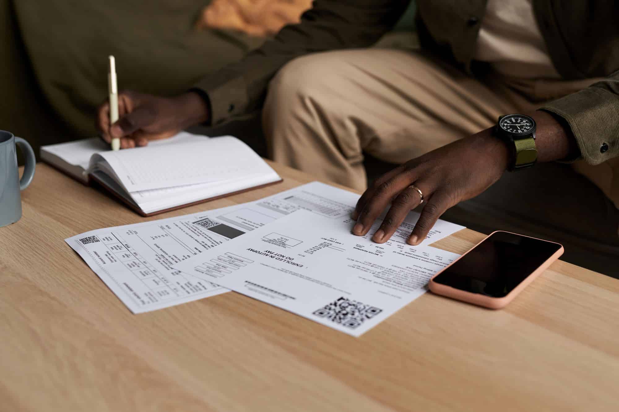 Black man doing taxes at home and filling out paperwork