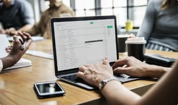 Person using laptop showing EDI data comparison interface in modern office workspace
