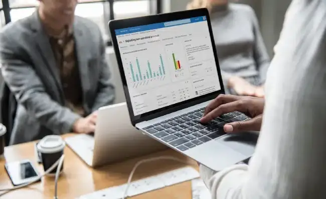 Team reviewing a supply analytics dashboard on a laptop during a meeting