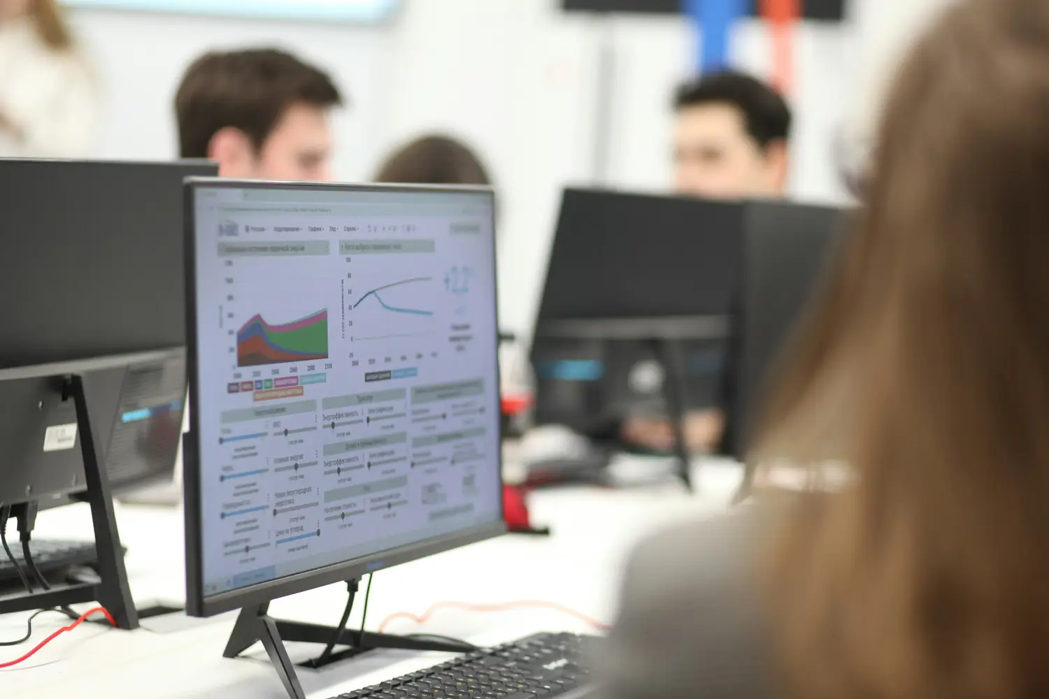 Engineer reviewing charts on a monitor in an open office