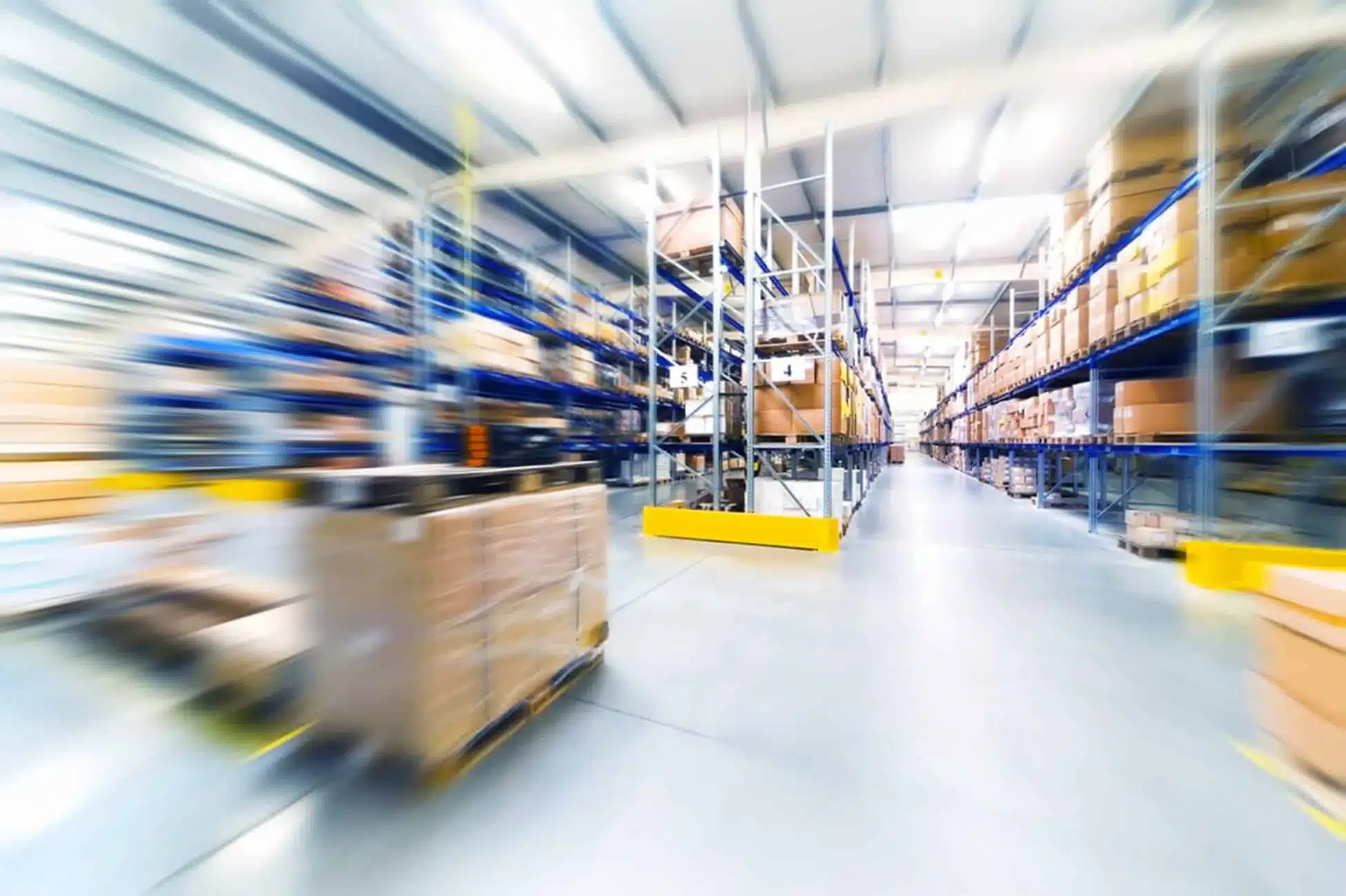 Modern warehouse with automated forklifts and inventory shelves showing EDI supply chain efficiency