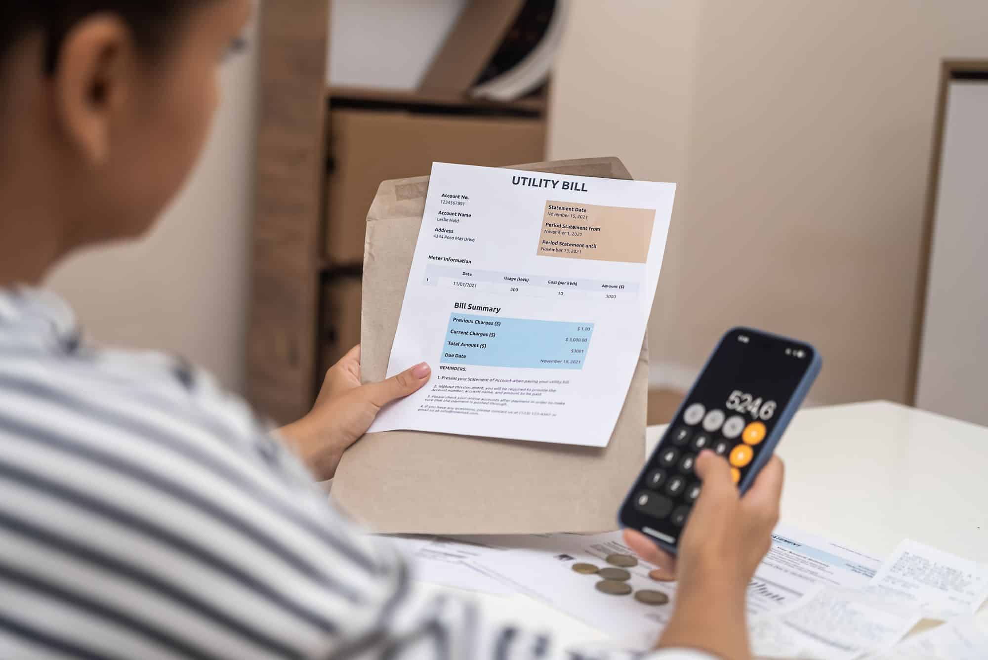 Woman examining bank account statements alongside utility bills