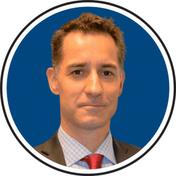 Professional headshot of Jan in business suit with red tie