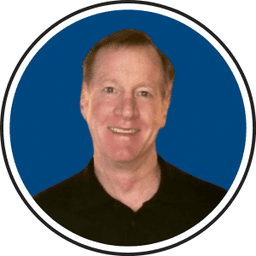 Professional headshot of Mark, smiling man in dark shirt against blue background