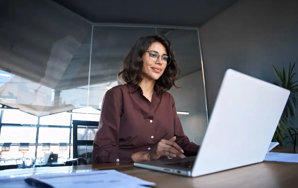 female professional on laptop doing edi 855 integration