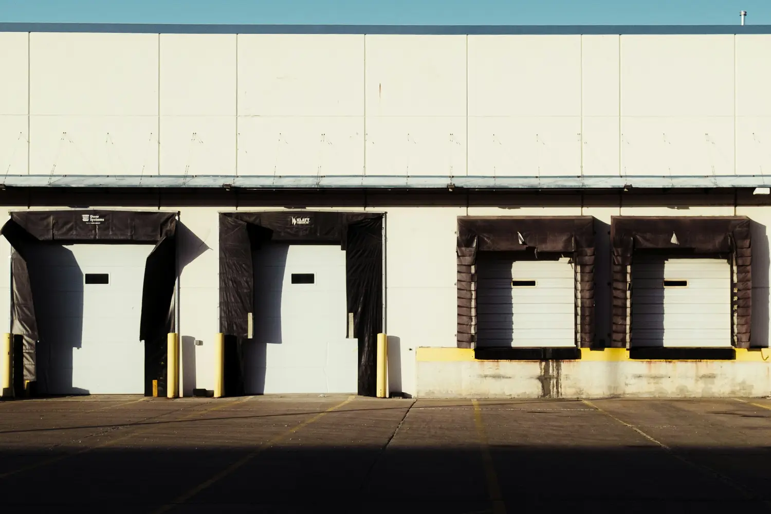 Row of closed loading dock doors with no trucks at them