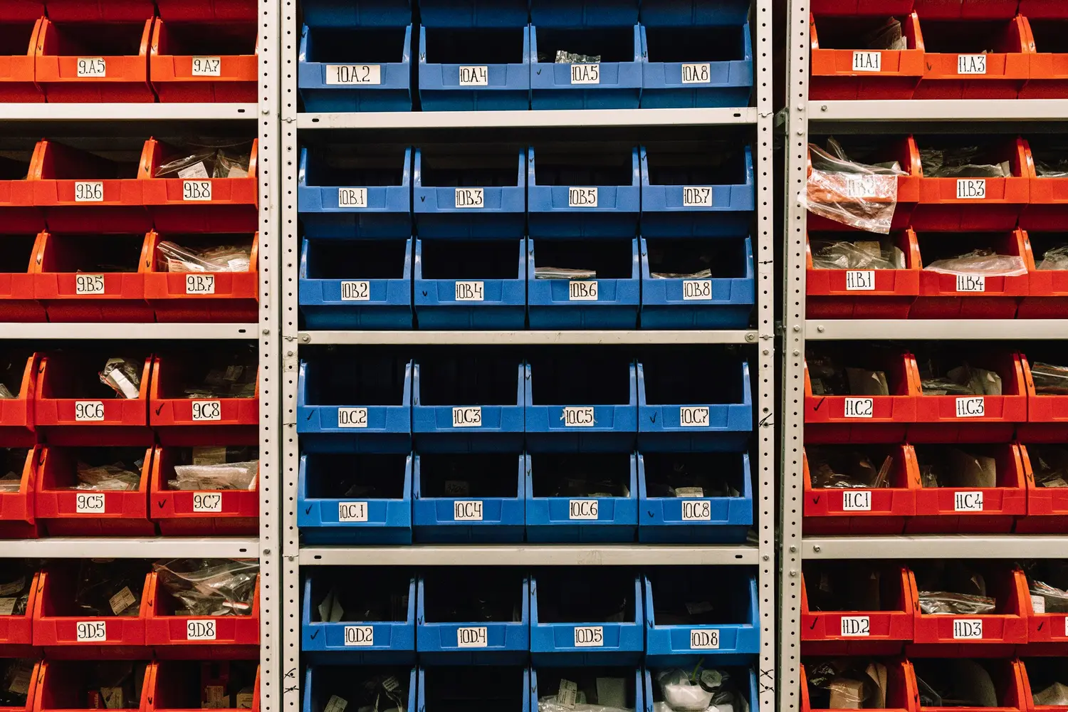 Shelving filled with labelled red and blue parts bins