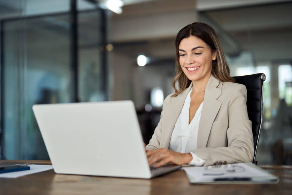 business woman looking at a laptop and smiling
