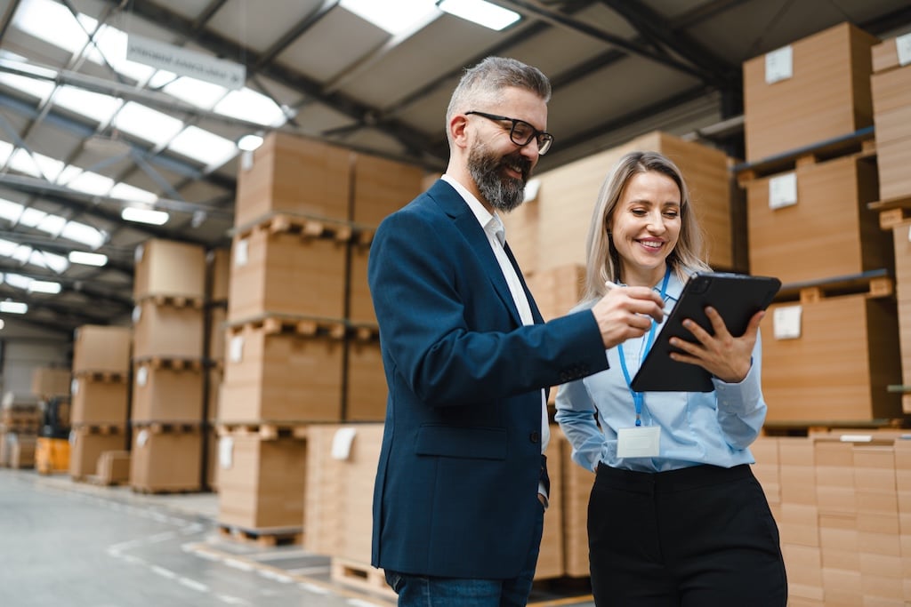 smiling professionals signing vendor management inventory document